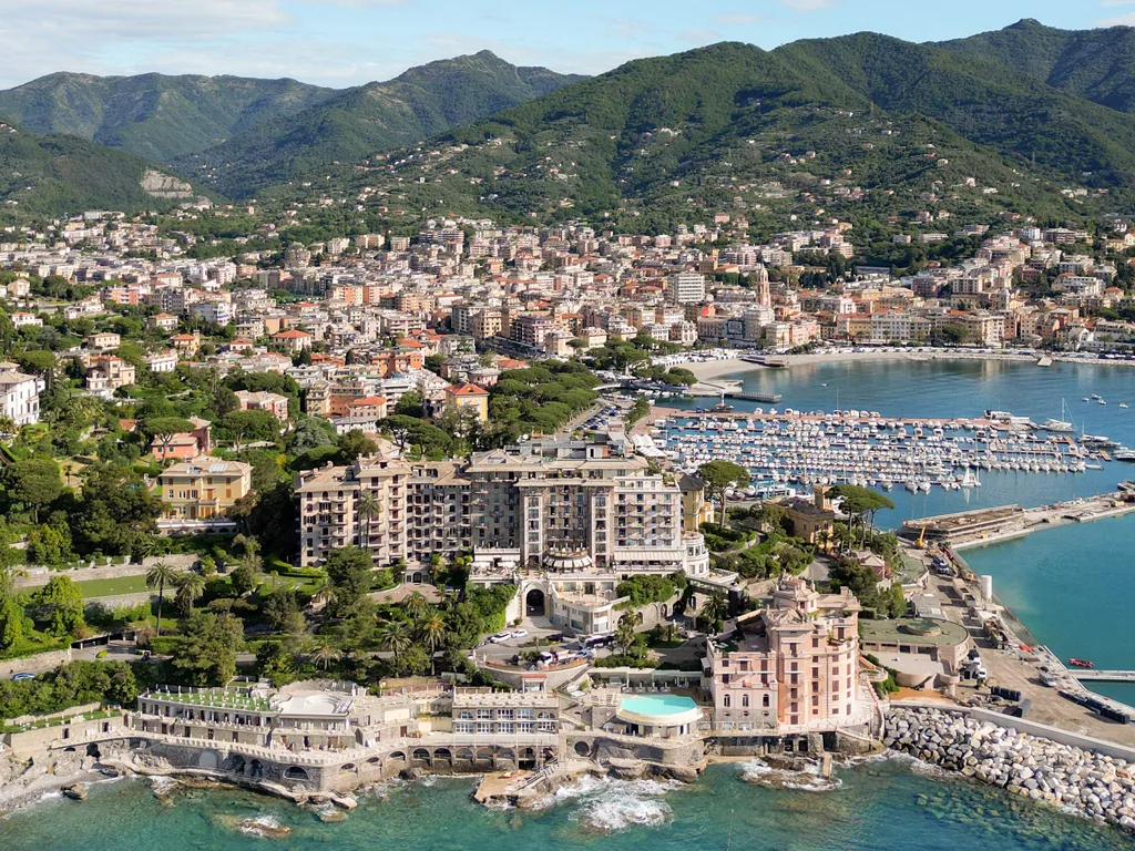 Veduta aerea della città costiera con hotel, porto turistico e colline