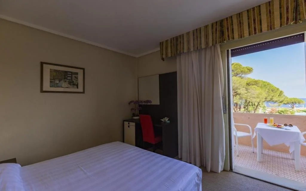 Camera con letto matrimoniale e balcone con tavolo per la colazione e vista mare