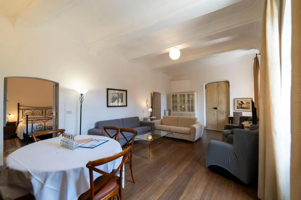Ampio soggiorno con divani, tavolo da pranzo e camera da letto attigua