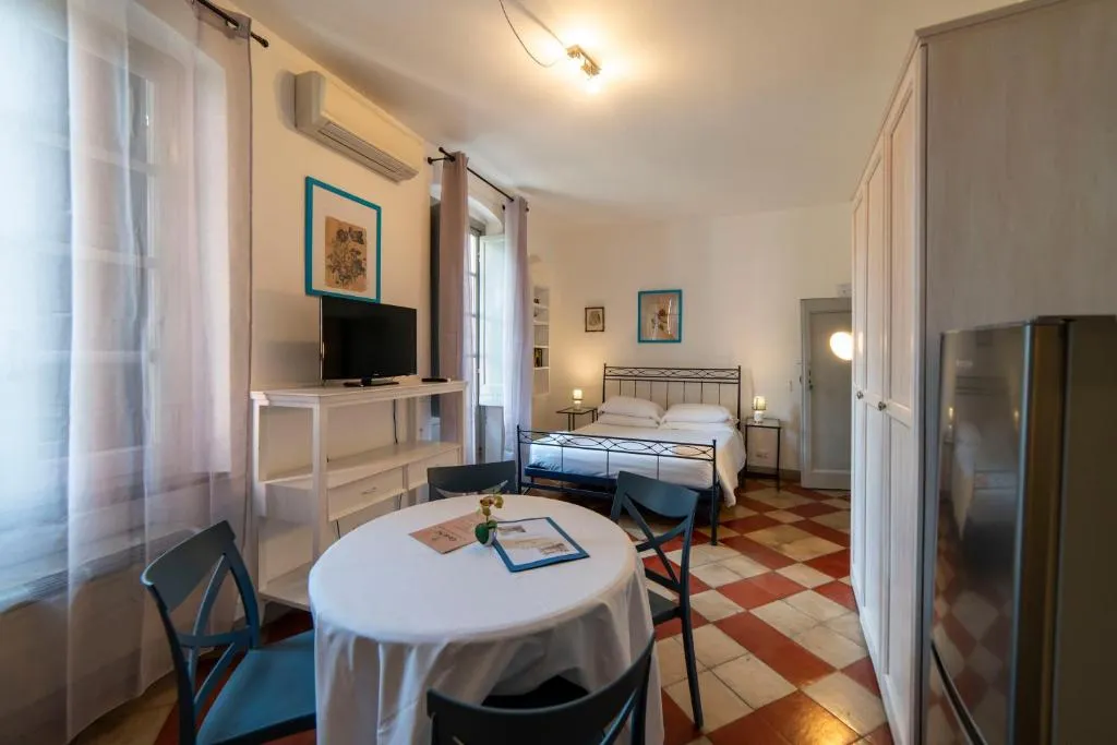 Monolocale con letto matrimoniale, tavolo da pranzo e pavimento a scacchi