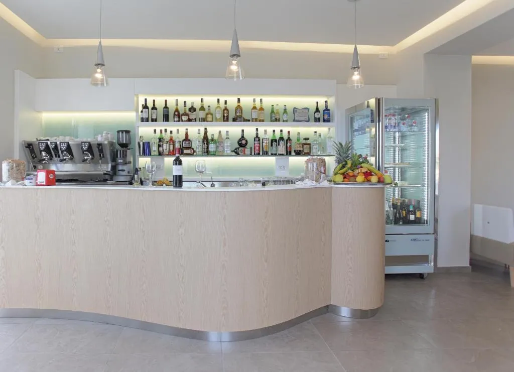 Bancone bar in legno con bottiglie, macchina del caffè e frutta fresca