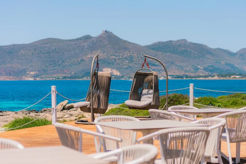 Terrazza con tavoli, sedute sospese e vista su mare e montagne