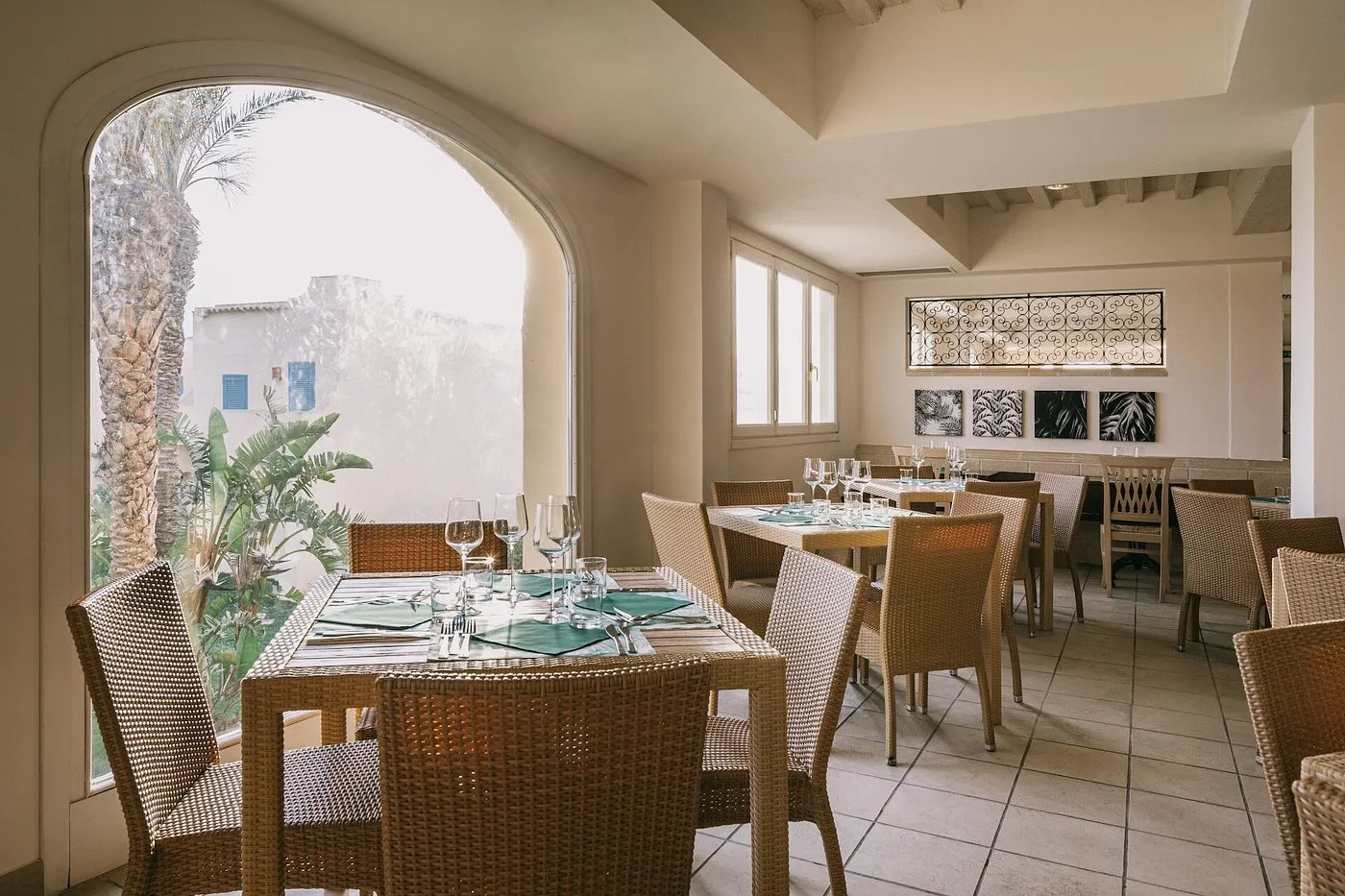 Sala ristorante interna con tavoli apparecchiati e ampia finestra ad arco