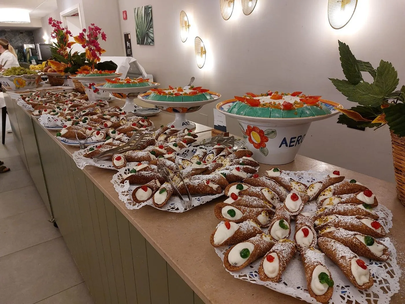 Buffet di dolci siciliani con cannoli e dessert su vassoi decorati