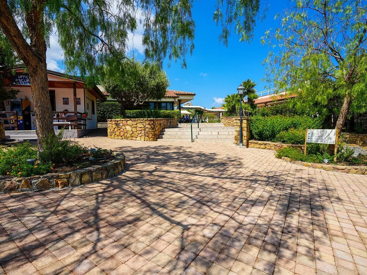 Vialetto pavimentato del resort con alberi, gradini e ufficio escursioni