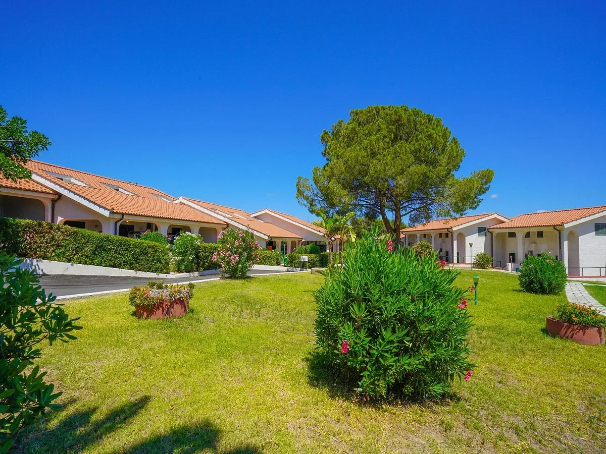 Giardino curato con villette dai tetti in cotto e cielo azzurro