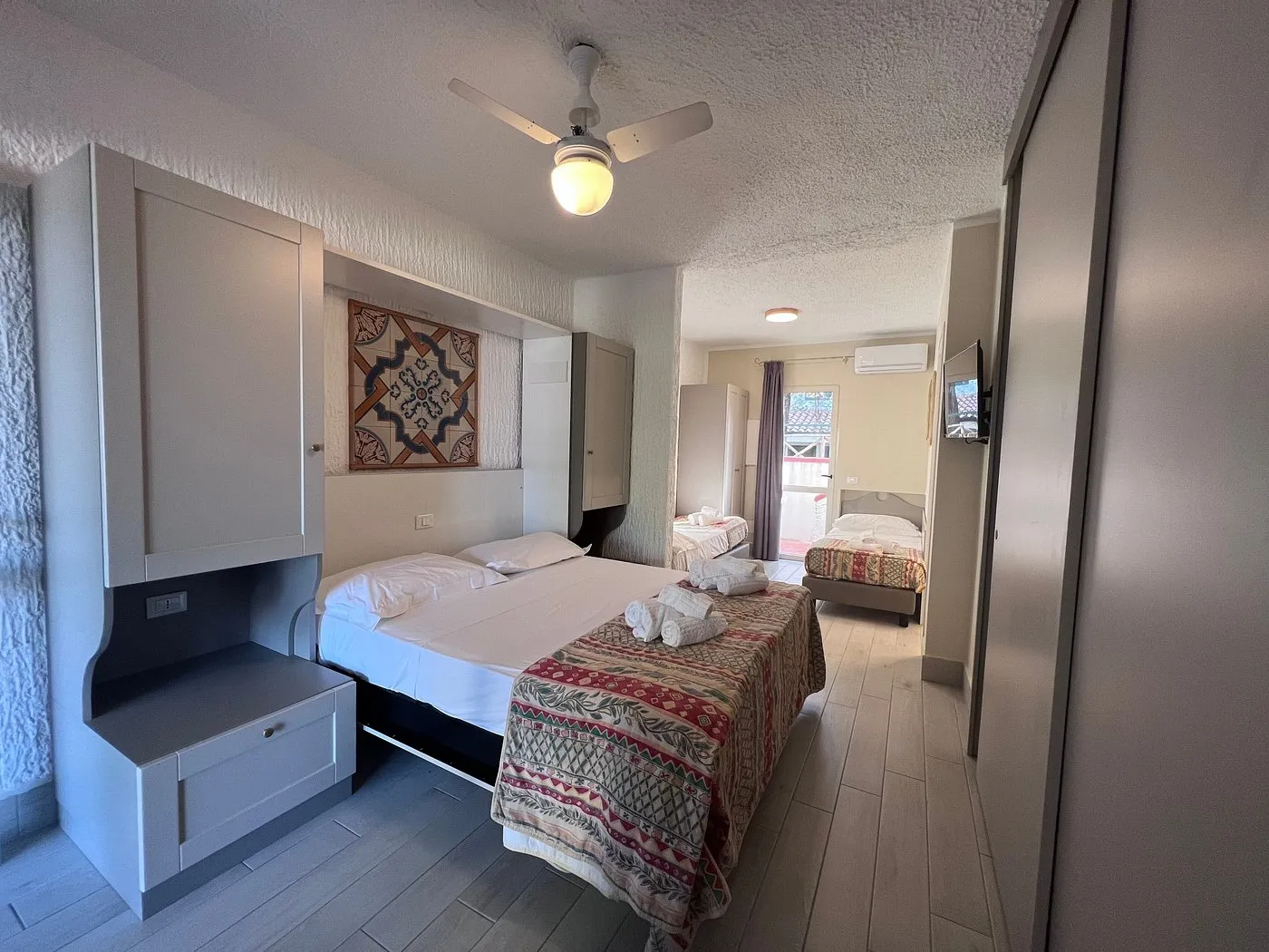 Camera familiare con letto matrimoniale e letto singolo, arredi chiari