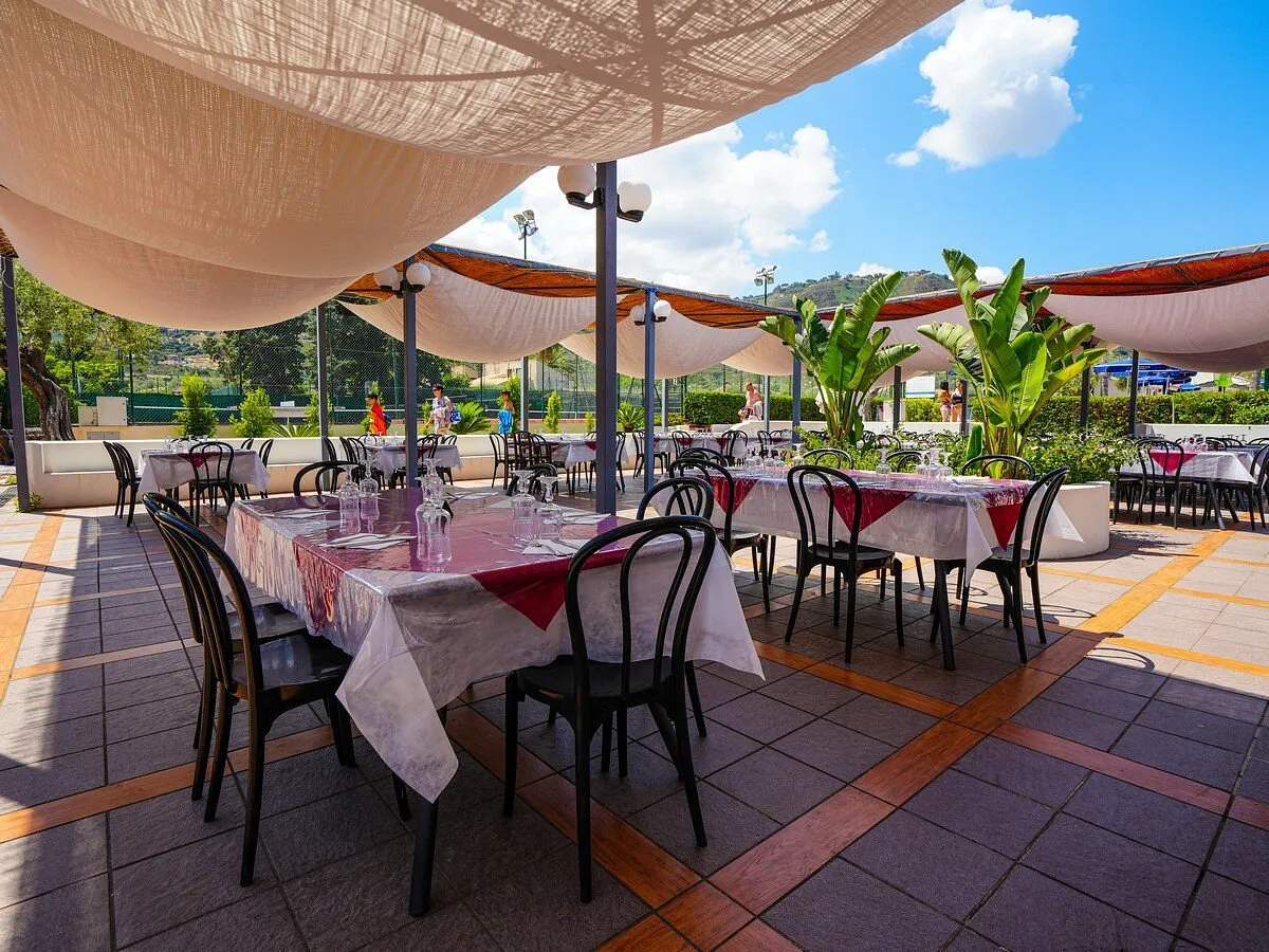 Ristorante all'aperto con tende ombreggianti e tavoli apparecchiati