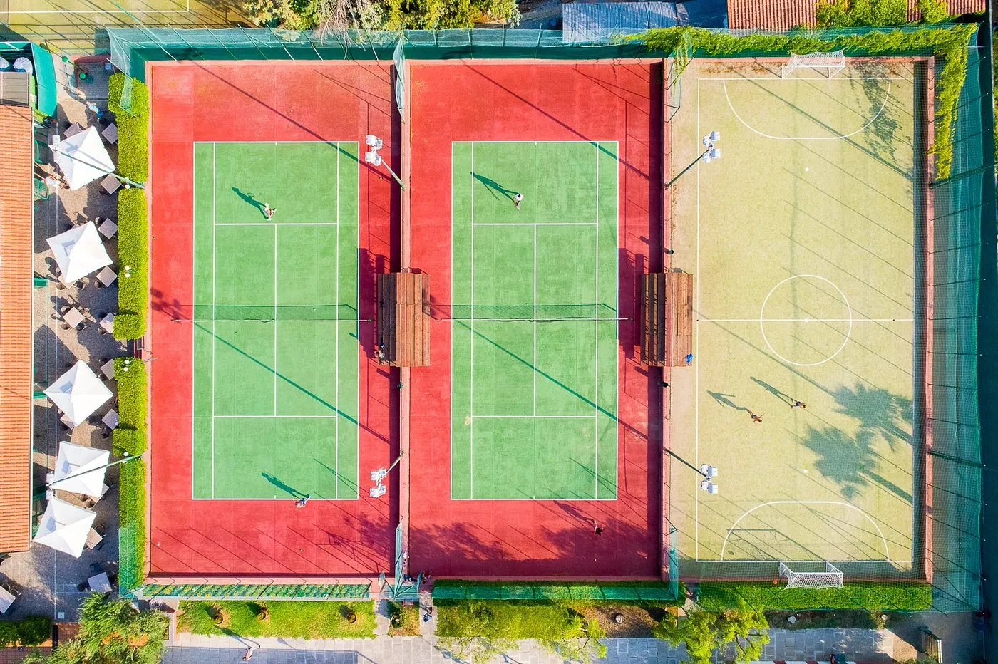 Veduta aerea dei campi da tennis e campo polivalente del resort