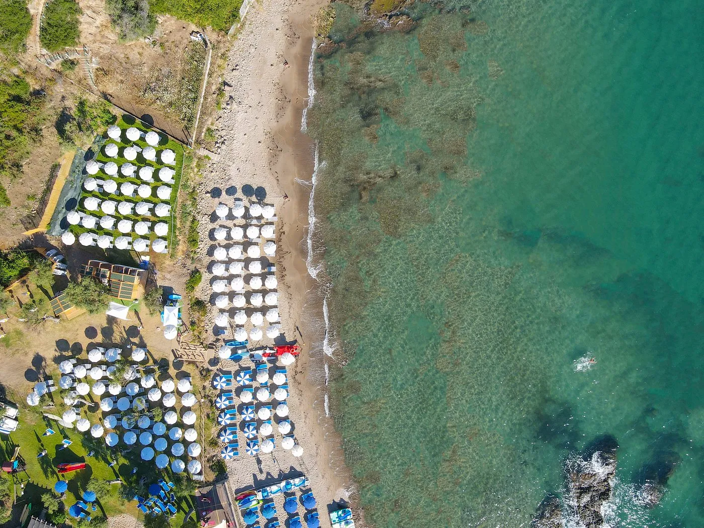 Vista aerea dall'alto della spiaggia con ombrelloni e mare turchese