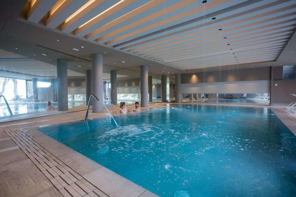 Piscina interna riscaldata con idromassaggio e ampie vetrate