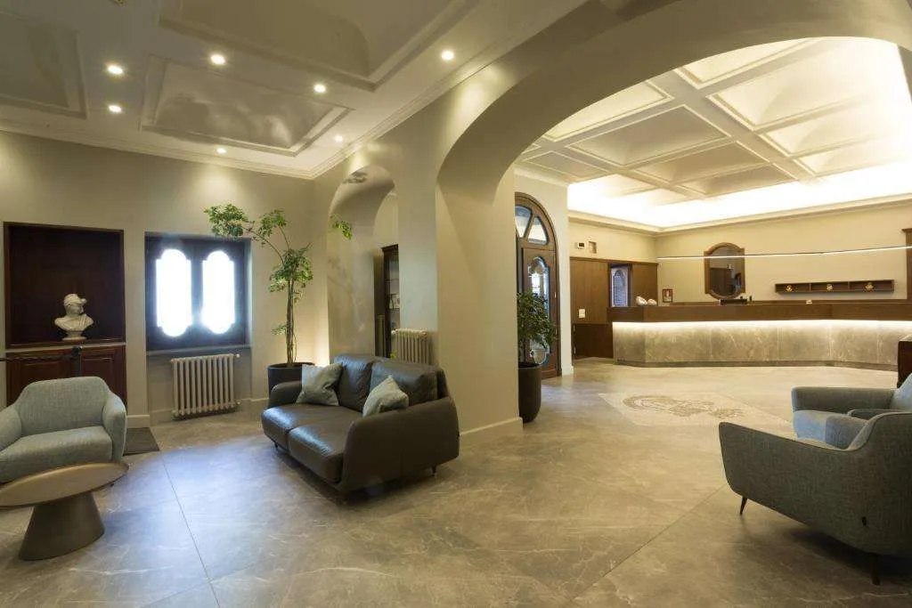 Ampia hall con divani in pelle, soffitti a cassettoni e reception