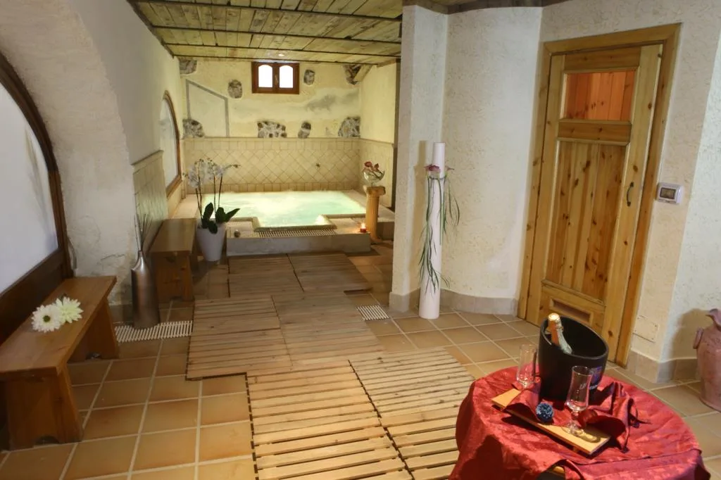 Area benessere con vasca idromassaggio, pedana in legno e sauna
