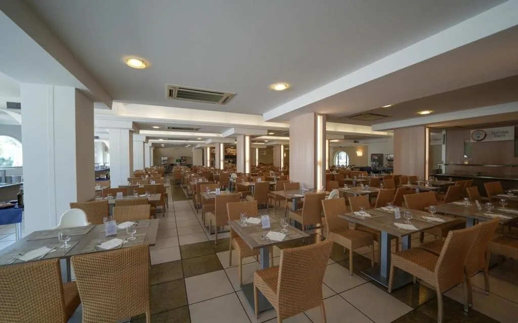 Sala ristorante interna ampia con tavoli e sedie in vimini