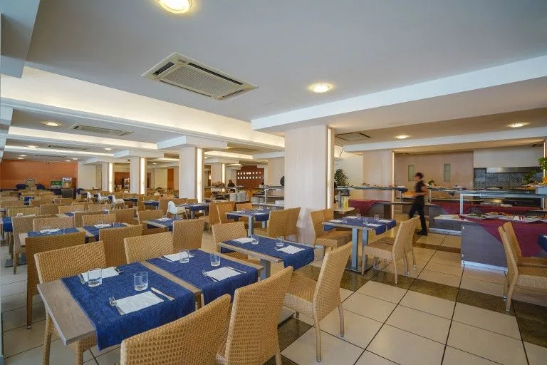 Sala ristorante interna con tavoli apparecchiati e buffet