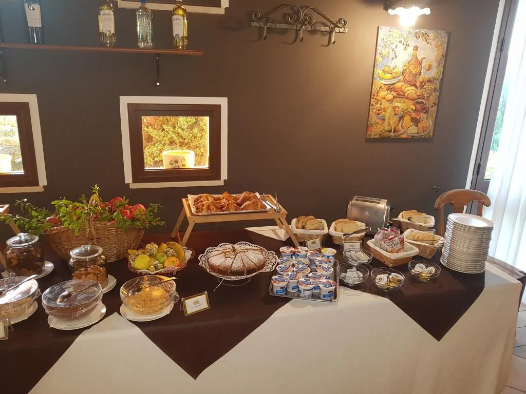 Tavolo del buffet con cornetti, torta, pane e yogurt per la colazione