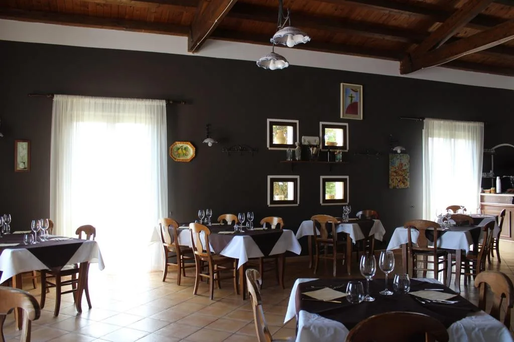Sala ristorante con tavoli apparecchiati e soffitto in legno