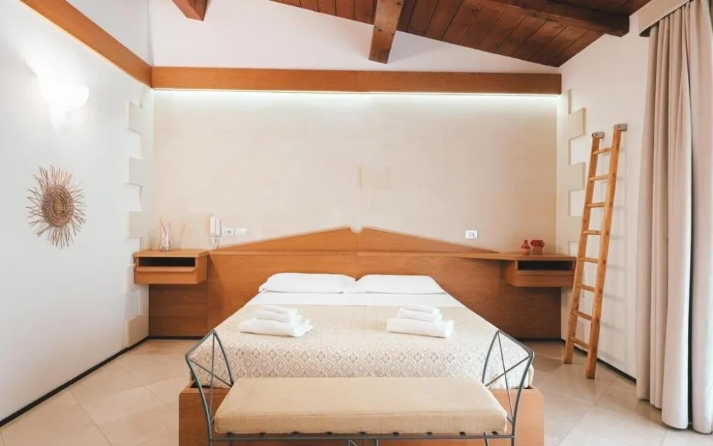 Camera luminosa con letto matrimoniale e soffitto in legno a vista