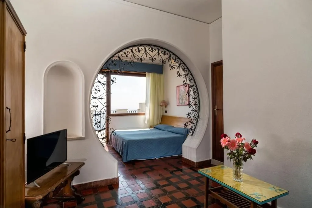 Camera con arco decorativo in ferro battuto che incornicia il letto con vista